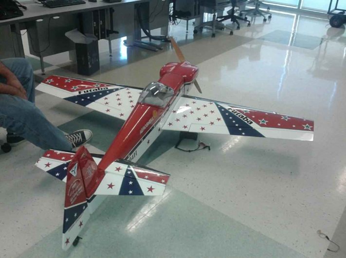 Students preparing a fixed-wing uncrewed aircraft in a classroom.