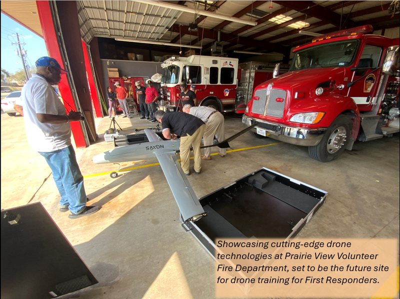 Drone equipment set up in the Prairie View Volunteer Fire Department apparatus bay, beside fire engines.